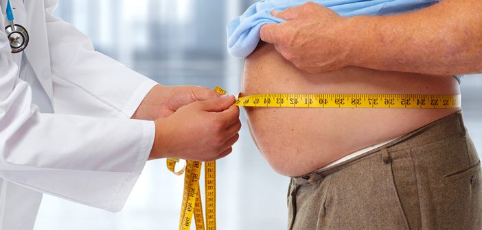 врач измеряет объем талии у мужчины